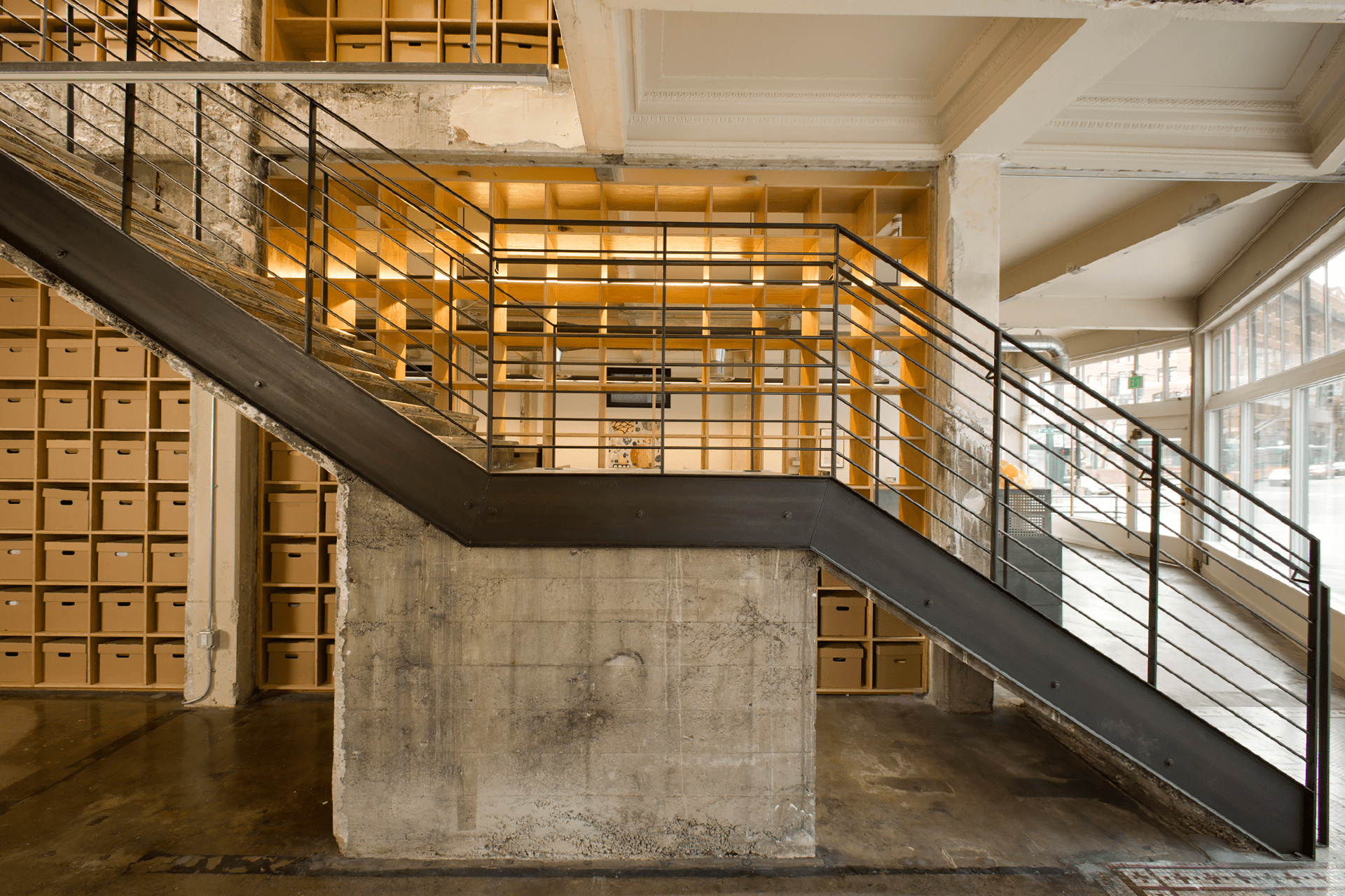 The interior of the 4Culture building has an industrial-looking staircase with black metal railing.