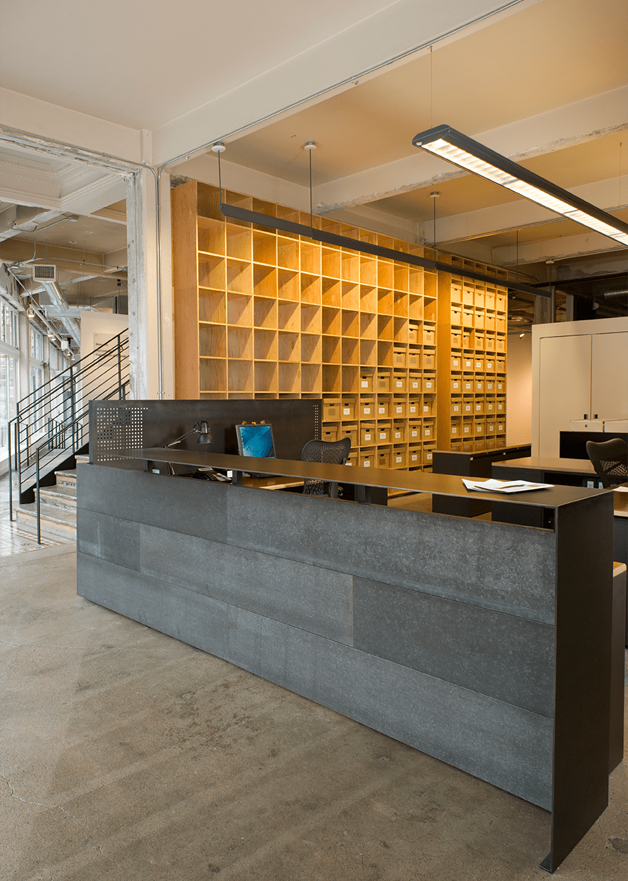 The reception area at the 4Culture building has rows of mailboxes and a black stone reception desk.