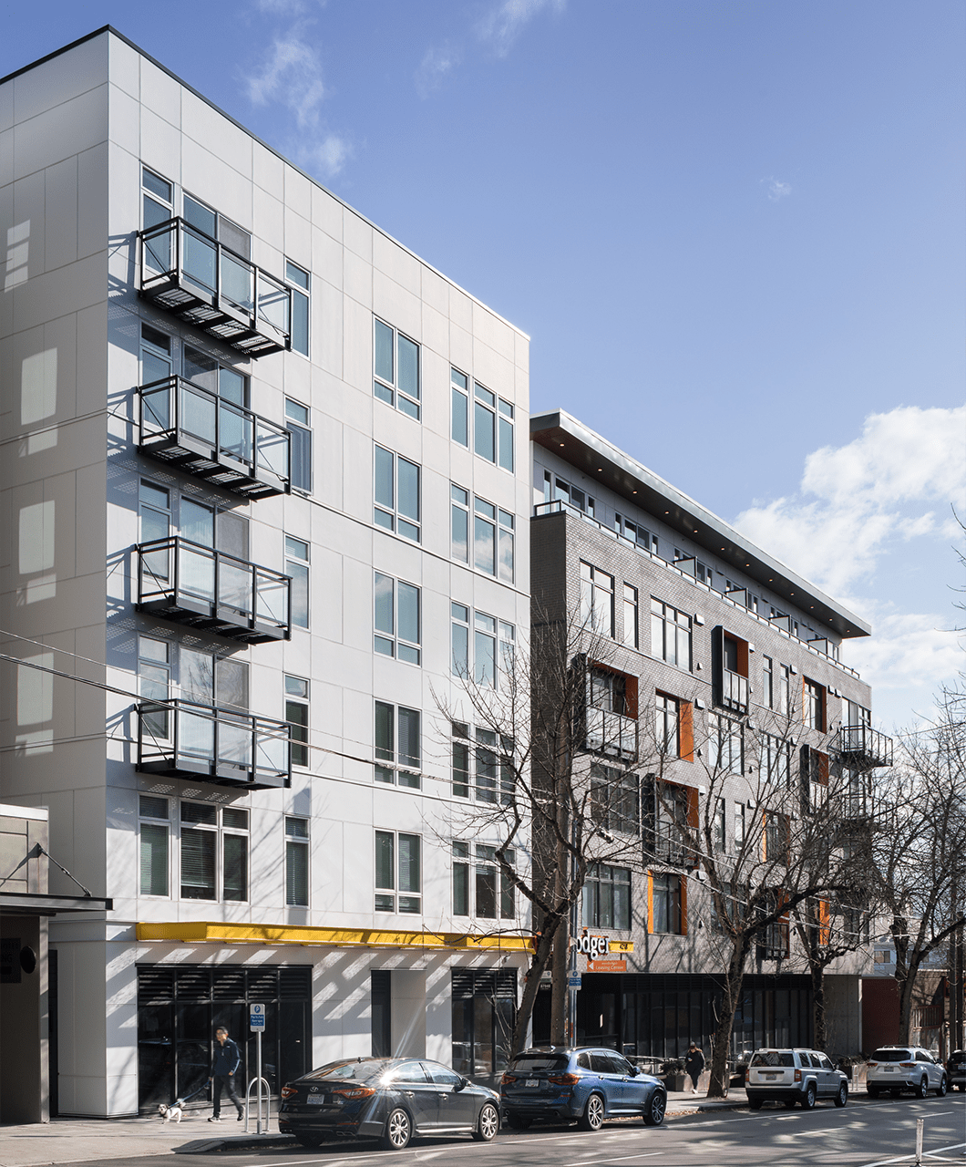 The exterior of the Roosevelt Apartments building features white and gray brick siding with jutted balconies.