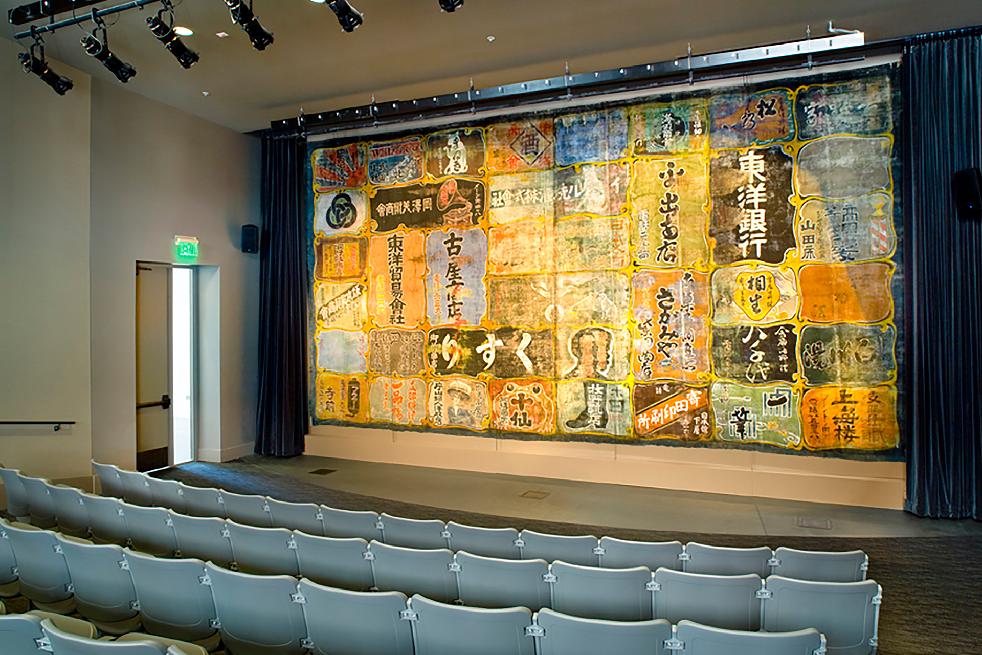 An auditorium at the Wing Luke Museum features a small stage and rows of seating.