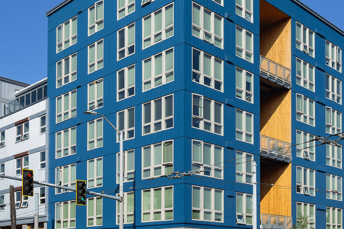 The exterior of the redeveloped Jackson building has a blue exterior, tall white windows, and large, recessed balconies.